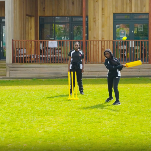 A PE lesson in action with the students playing cricket on the school PE field